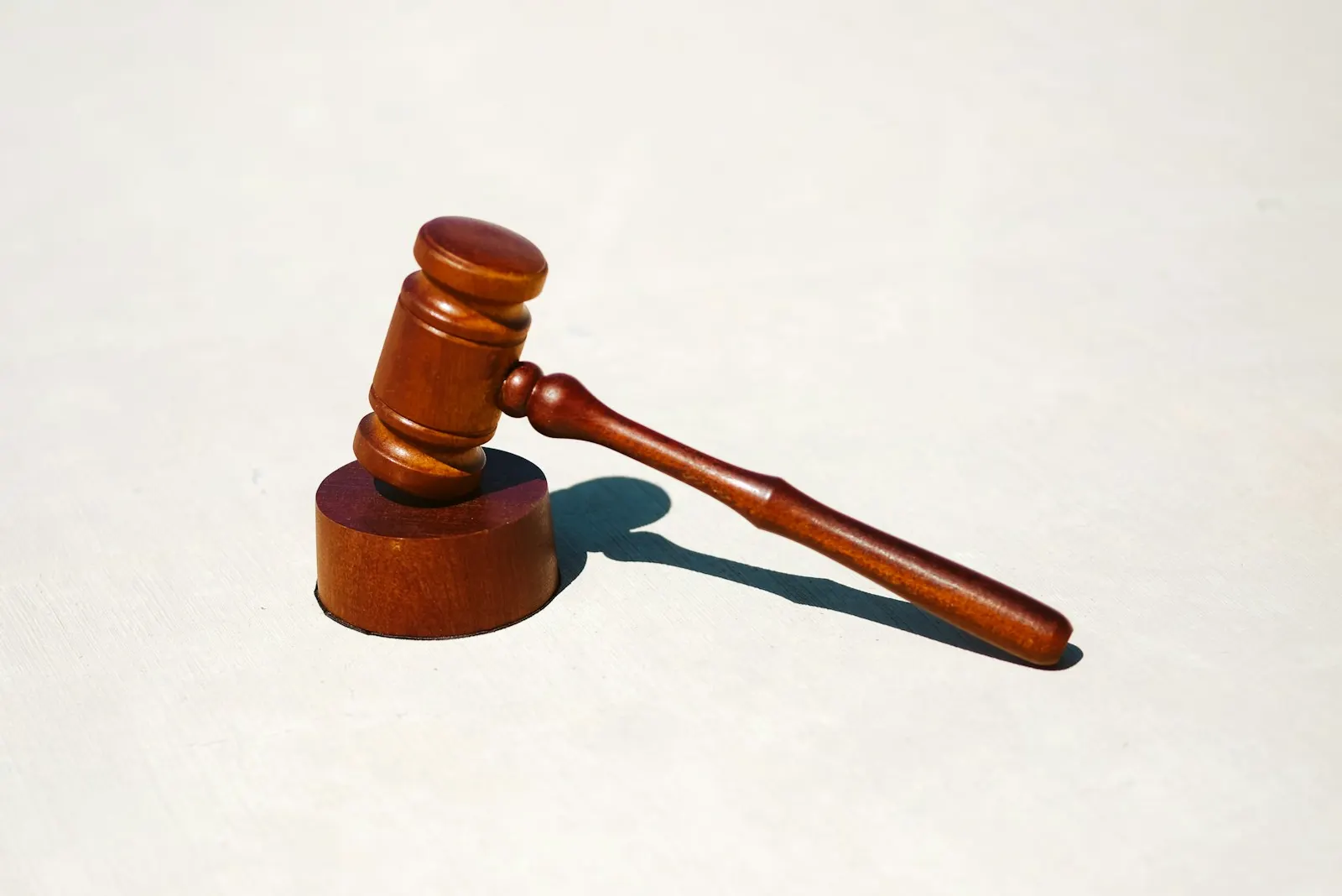Wooden judge's gavel on a white surface